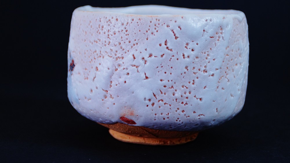 Further side view of the chawan made of Shino ware by Jyuzo Sato with irregular walls