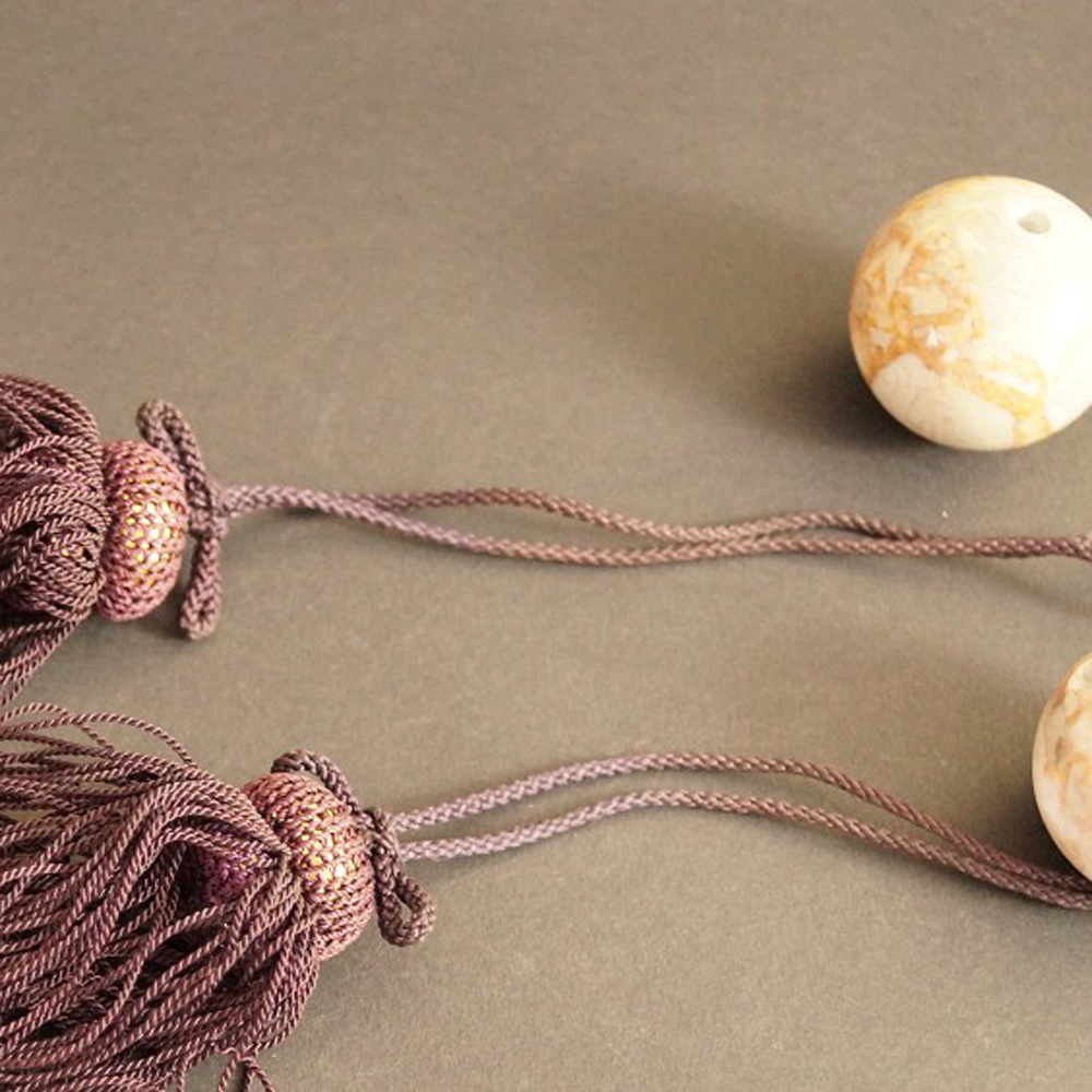 Two Orange Marbled Natural Stone Spheres with Mauve Silk Tassels Set Close-Up Preview