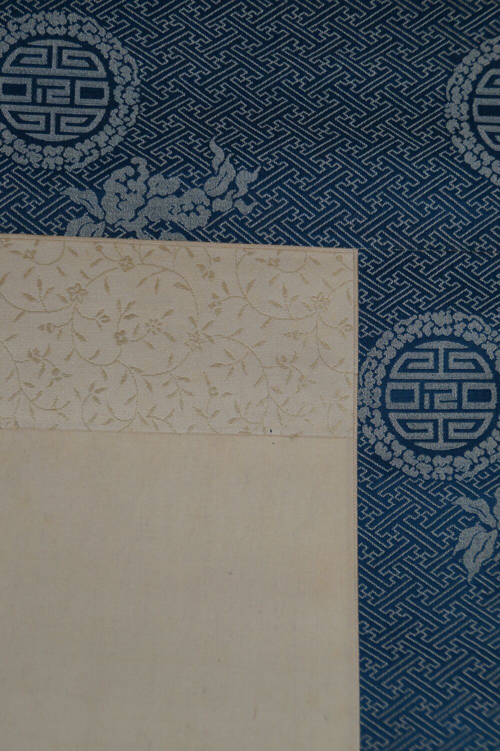 Detail View of the Blue Silk Mounting with Round Medallion Pattern and Cream-Colored Picture Edge of the Kakemono Japanese Eggplant