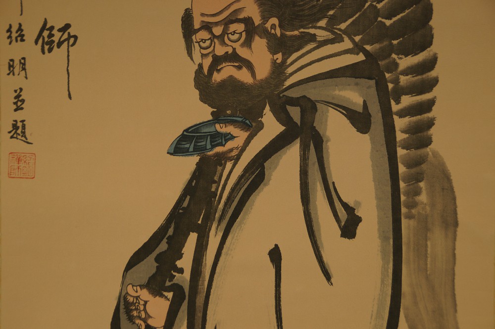 Close-up of Bodhidharma's face with fan and colophon text