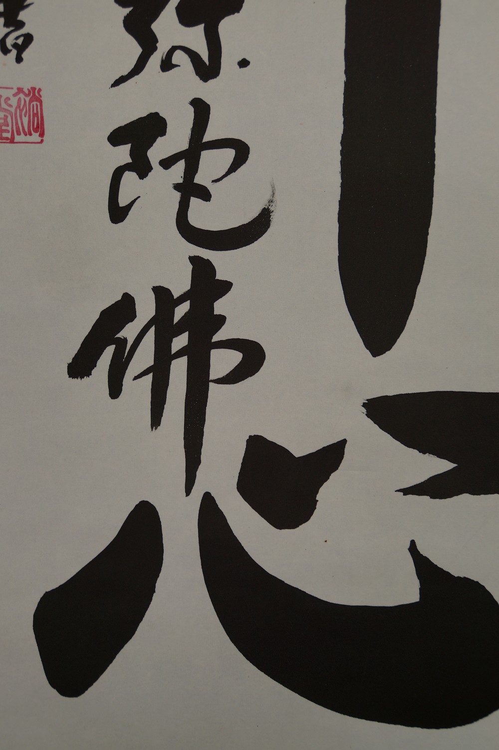 Close-up of the characters Mida Butsu Shin with red seal