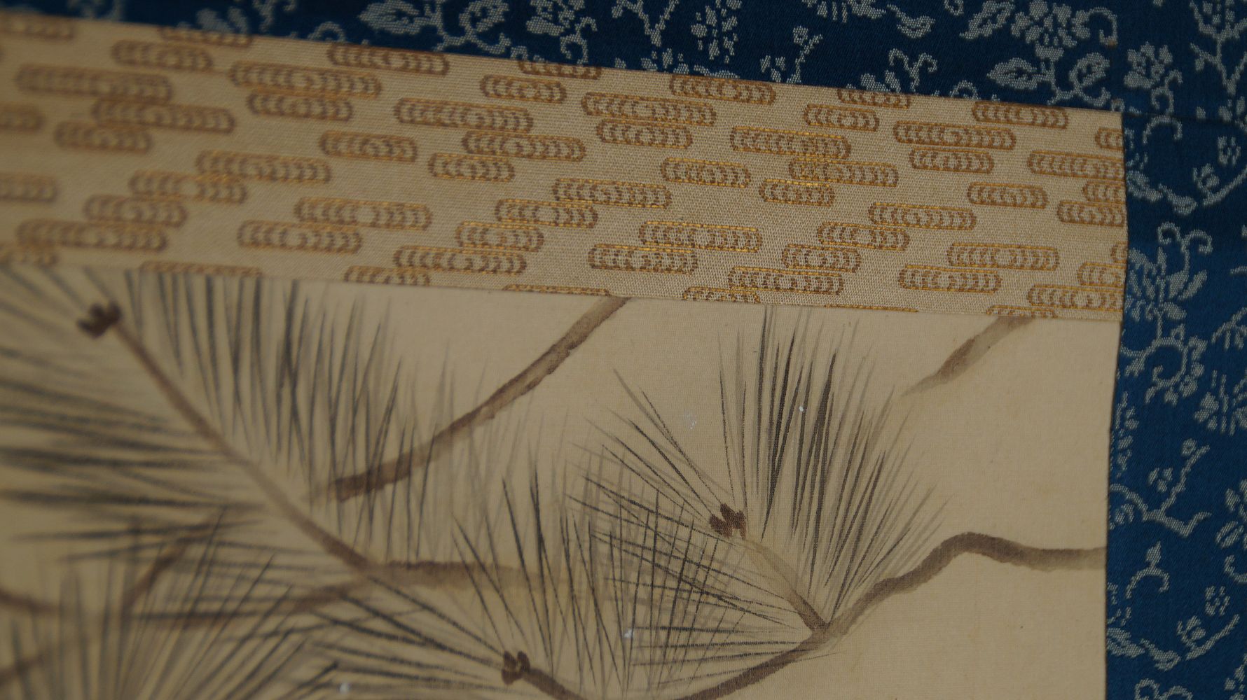 Detail view of the blue brocade mounting with floral pattern at the upper edge of the hanging scroll Carp in a Turbulent Waterfall