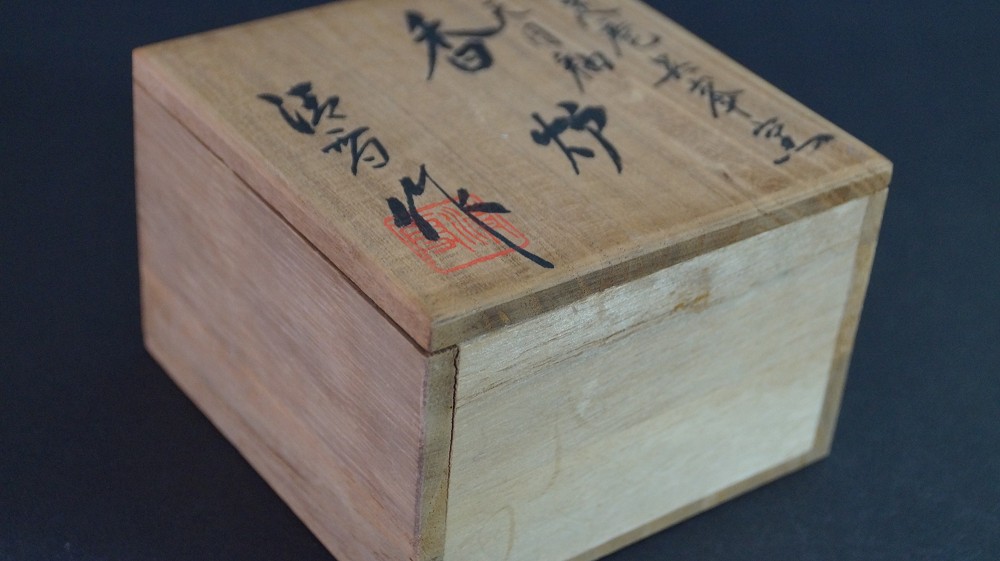 Close-up of the inscription Tenmoku-Yu Kouro on the lid of the storage box made of kiri wood