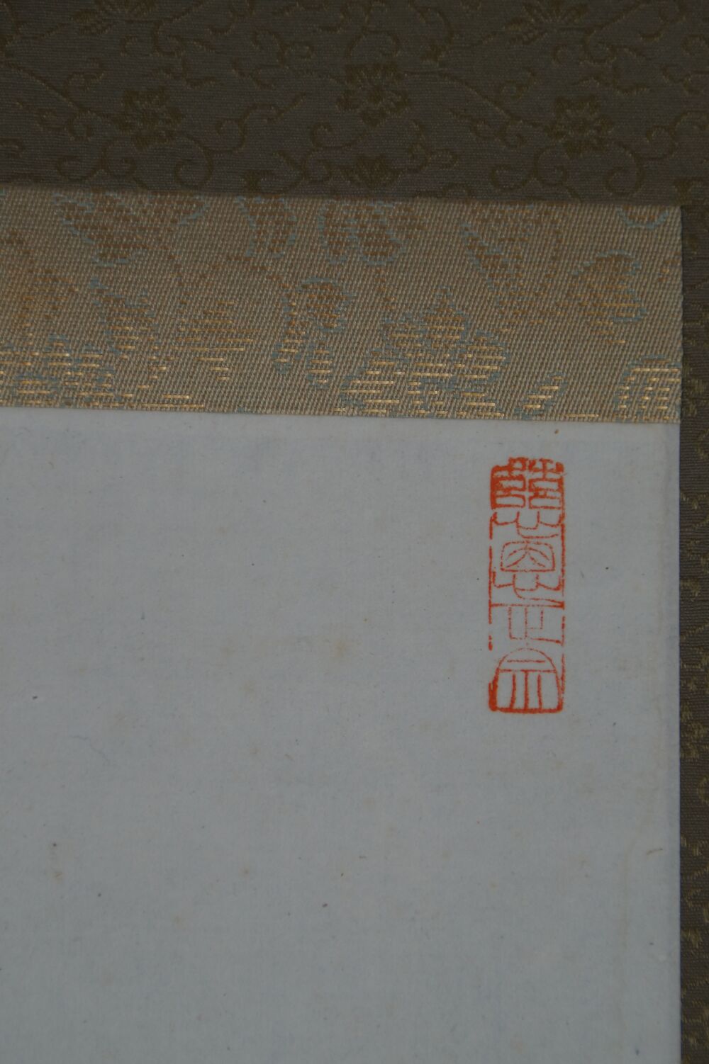 Detail view of the patterned silk mounting with red seal at the edge of the hanging scroll calligraphy Shoaku Makusa