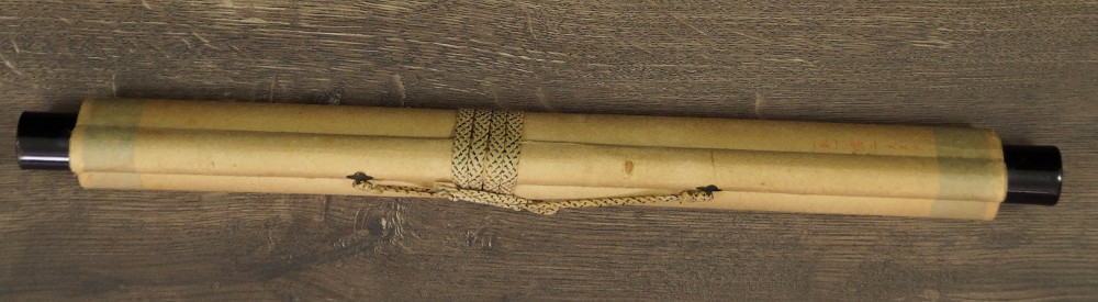Rolled up hanging scroll tied with cord with jikusaki made of wood