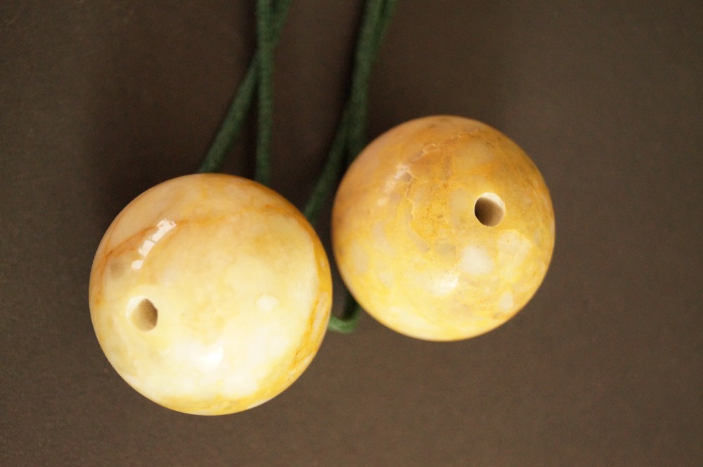 Two pierced yellow marbled stone spheres Stone Close-Up 1