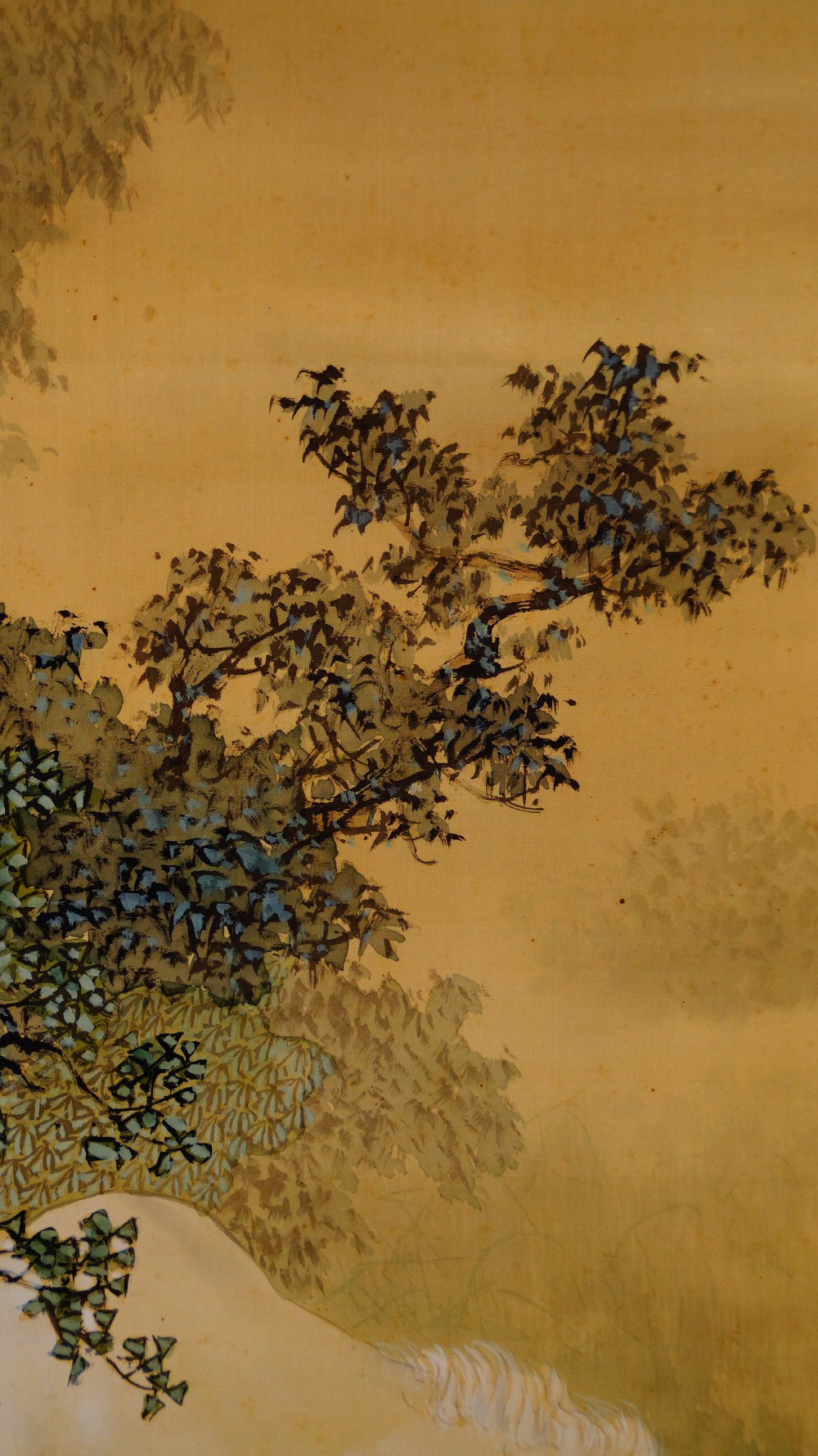Close-up of the blue-green leaves and berries of the tree on the hanging scroll by Sobun