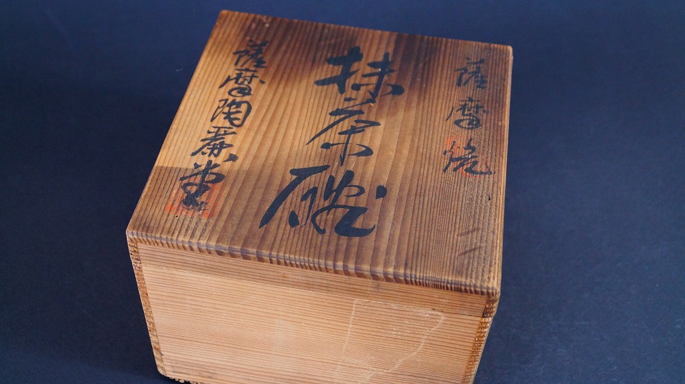 Closed storage box of the chawan made of Satsuma ware by Gyokusen Nozaki with the ink inscription Satsuma-yaki Matcha-Chawan and red seal