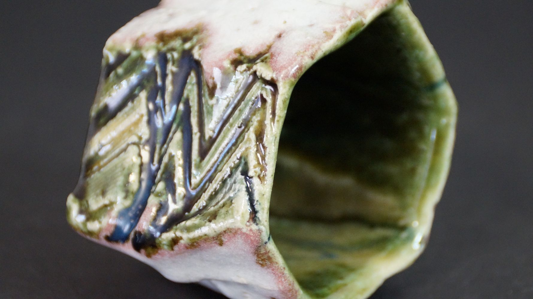 Additional close-up of the rim with incised zigzag pattern of the guinomi sake cup made of Oribe ware