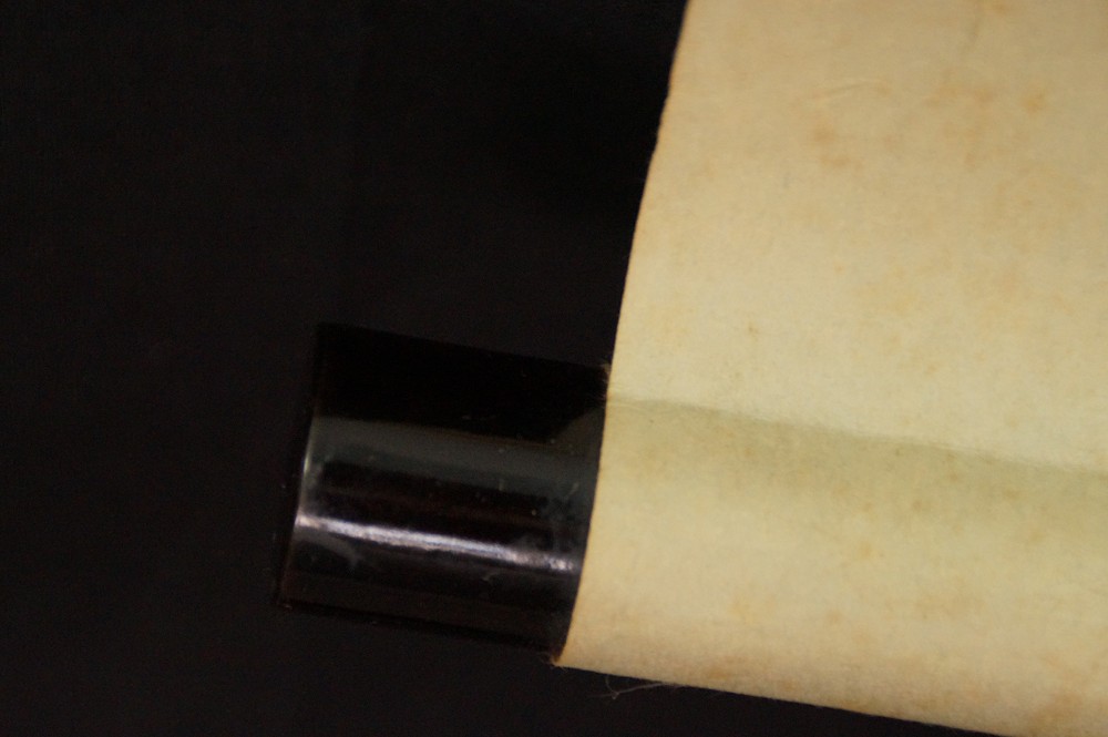 Close-up of the black lacquered jikusaki at the end of the scroll