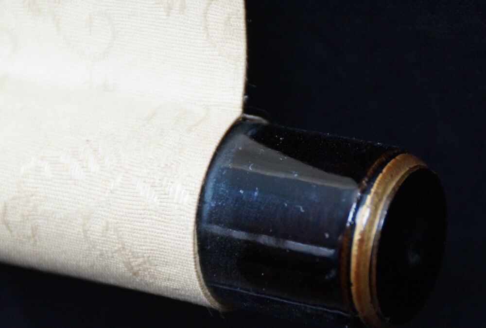Detail view of the black lacquered roller end with cream-colored silk of the Kakemono Young Woman in Front of Her Kimono Cabinet