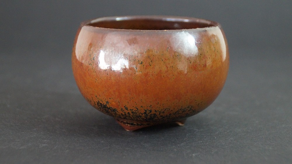 Side view of the chawan with brown tenmoku glaze on three small feet by Kurokawa Seisetsu