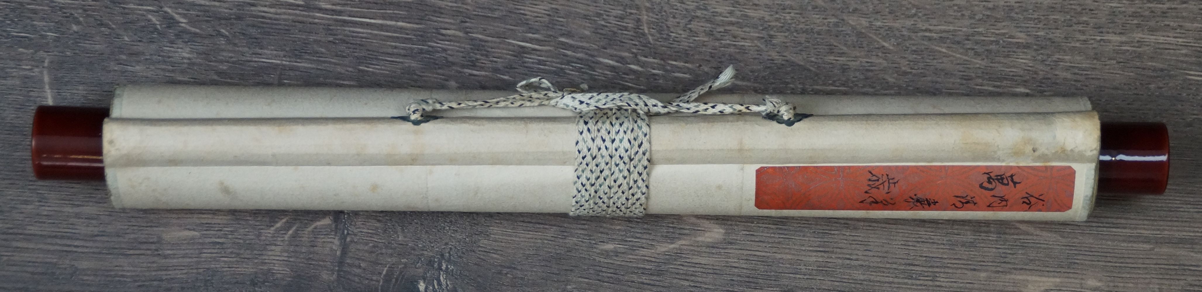 Zusammengerolltes Kakemono der Kalligraphie Banzai mit Verschlussband und Etikett