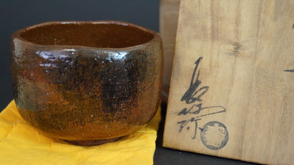Chawan made of Ohi ware next to the signed storage box with round artist's seal