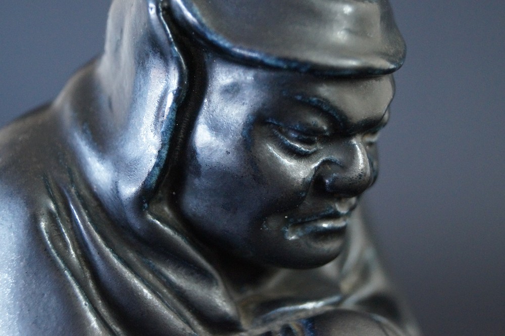 Bodhidharma Daruma Figur aus schwarzem Porzellan Gesicht Nahaufnahme 1