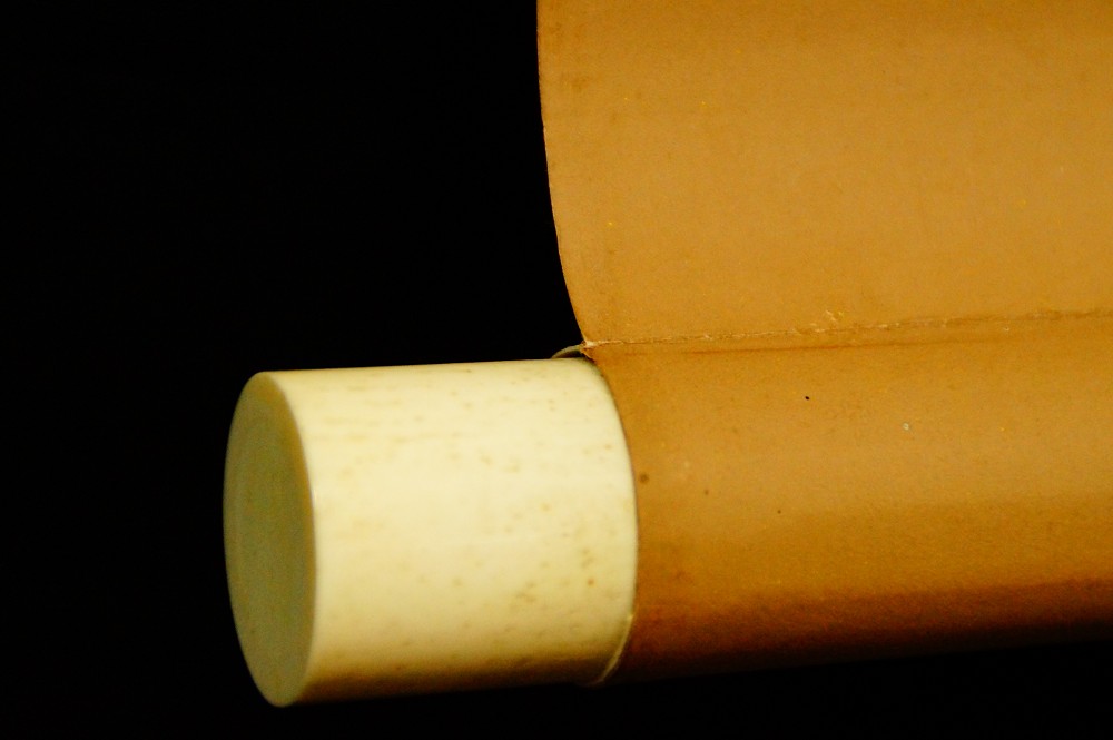 Close-up of the jikusaki made of bone at the end of the scroll