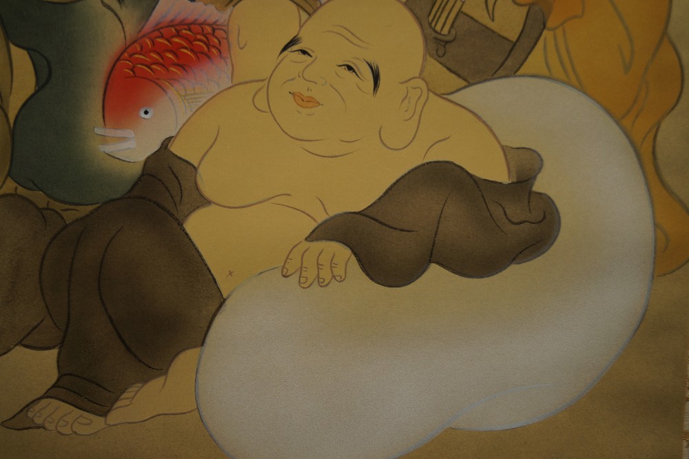 Nahaufnahme des lachenden Gottes Hotei auf seinem Gluecksbeutel Hotei Motiv Nahaufnahme