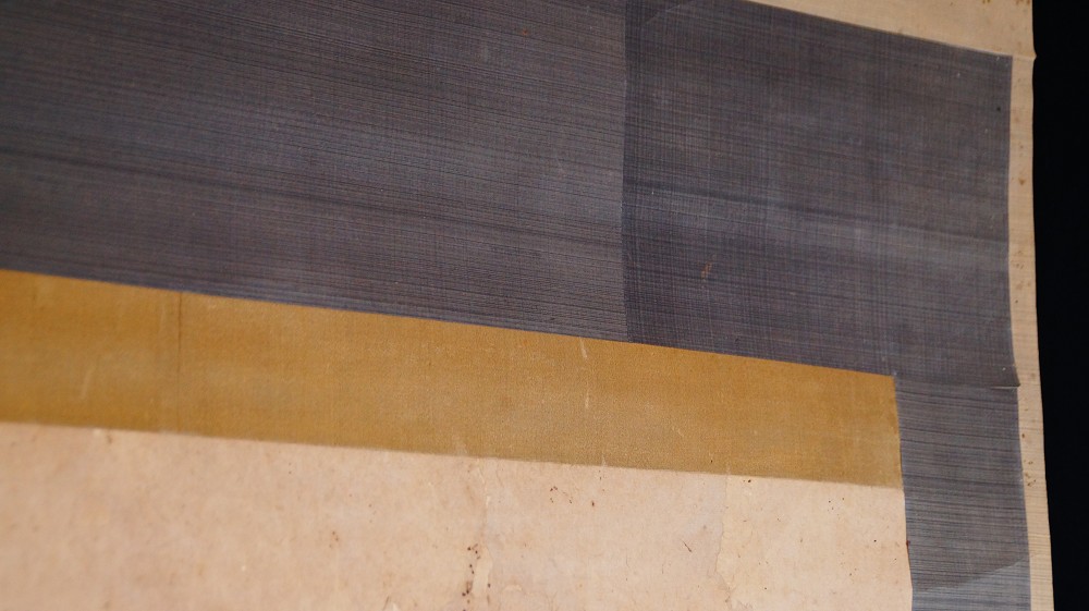 Detail of the gray-and-gold silk mounting of the kakemono