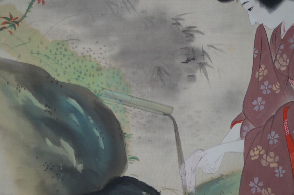 Close-up of hand and white cloth at the bamboo water spout with moss-covered rock and maple leaves in the Kakemono Lady in Kimono by the Garden Pond