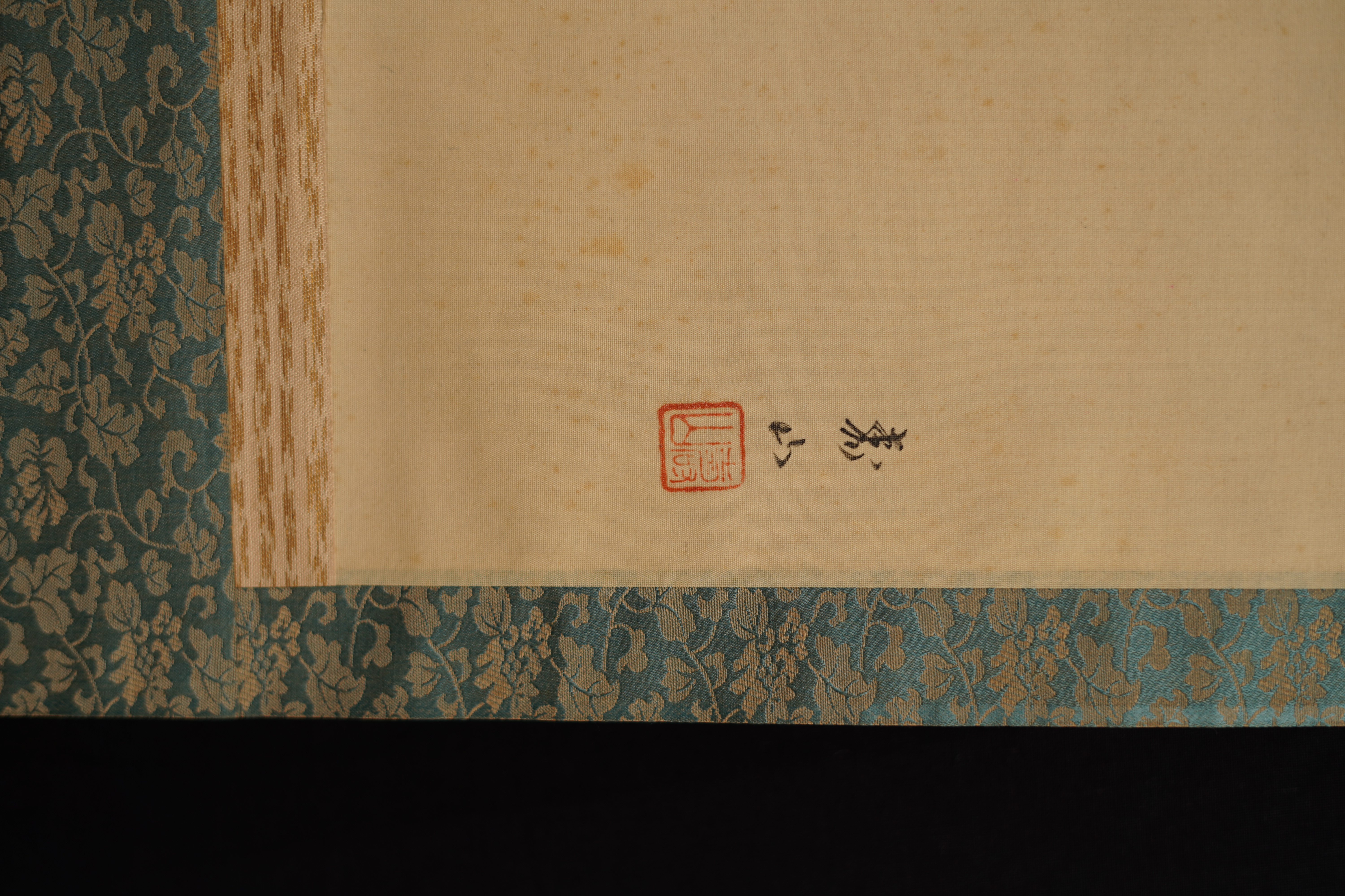 Further detail view of the artist's signature and the red seal with silk mounting in the Hanging Cherry Blossoms hanging scroll