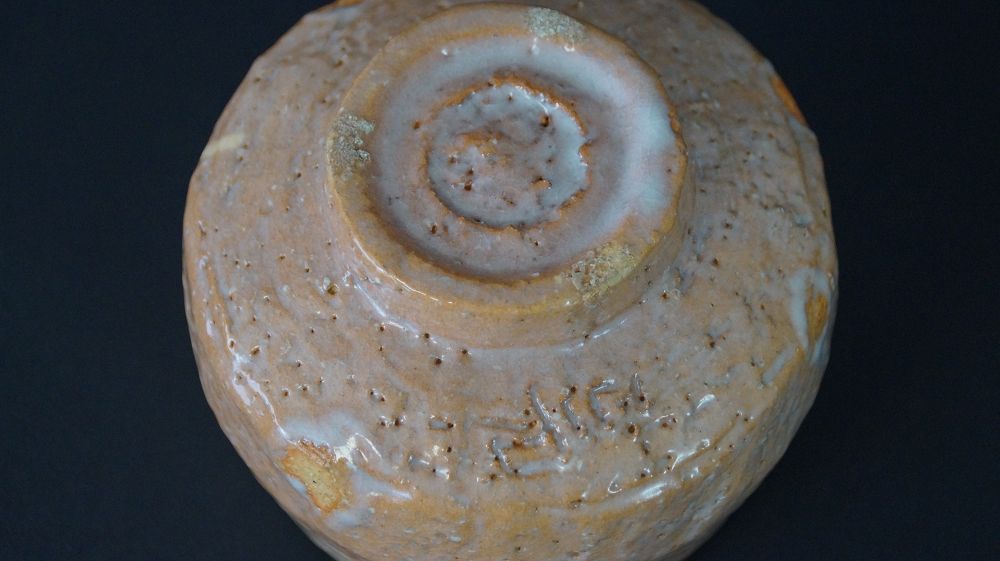 Detail view of the spirally turned foot with incised signature of the chawan tea bowl made of Raku ware