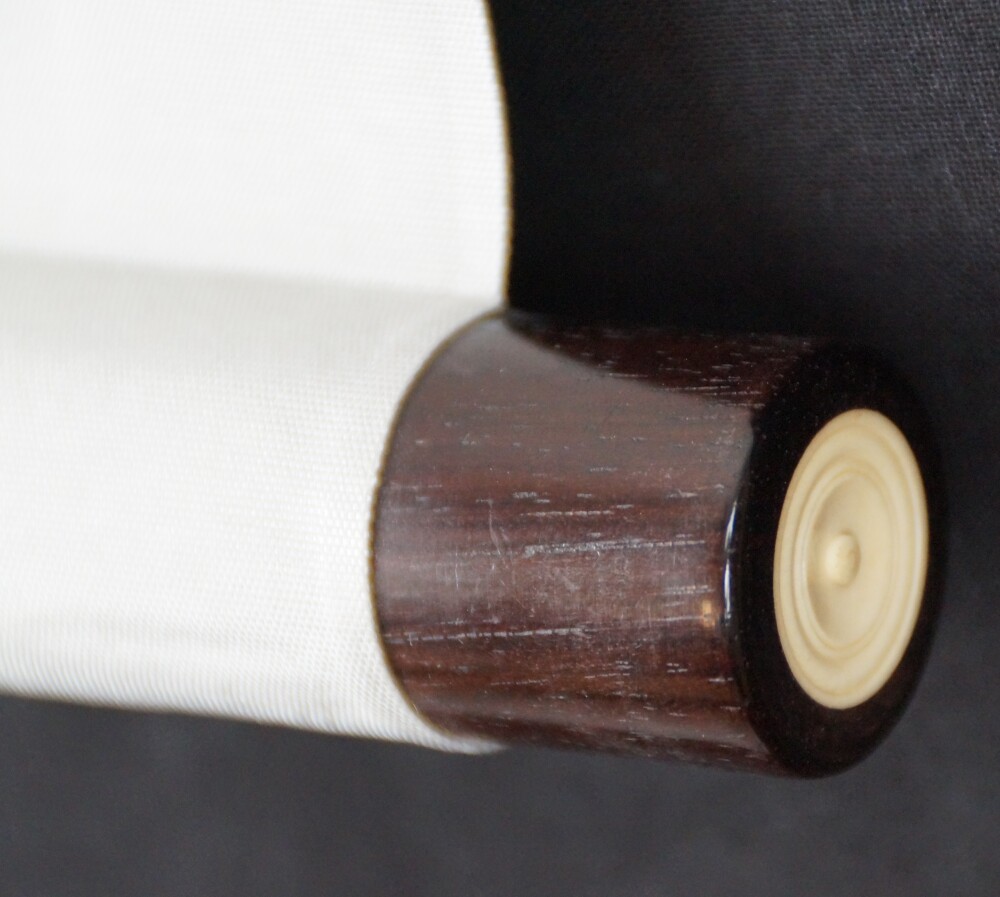 Close-up of the dark scroll end with ivory-colored knob on the hanging scroll Plum Blossoms in Quiet Early Light by Tokuoka Shinsen
