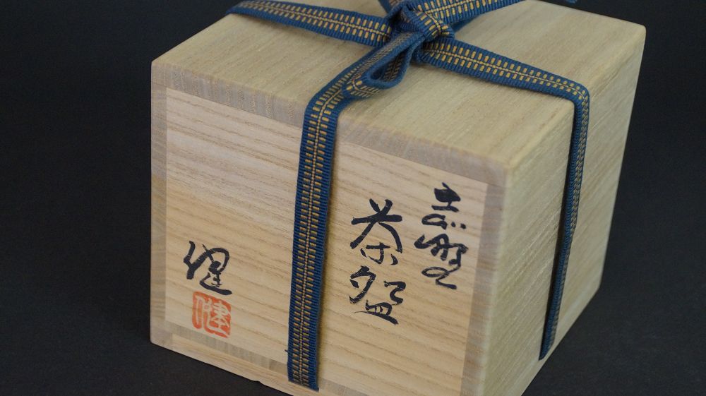 Closed storage box of the chawan made of Shino ware, tied with a blue-and-gold cord