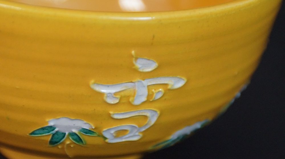 Further close-up of the white-painted character with chrysanthemum motif on the chawan made of Kyoto ware