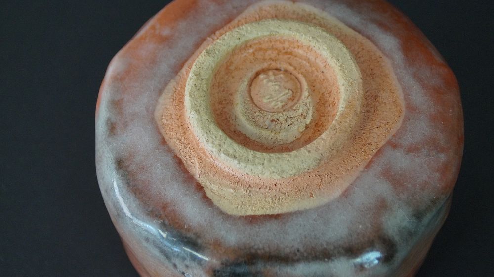 Detail view of the foot with impressed artist seal of the chawan tea bowl made of Raku ware