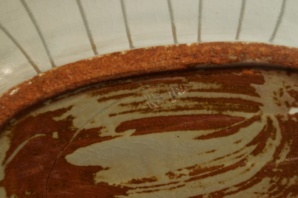 Extreme close-up of the stamped potter's mark on the bottom potter's mark close-up