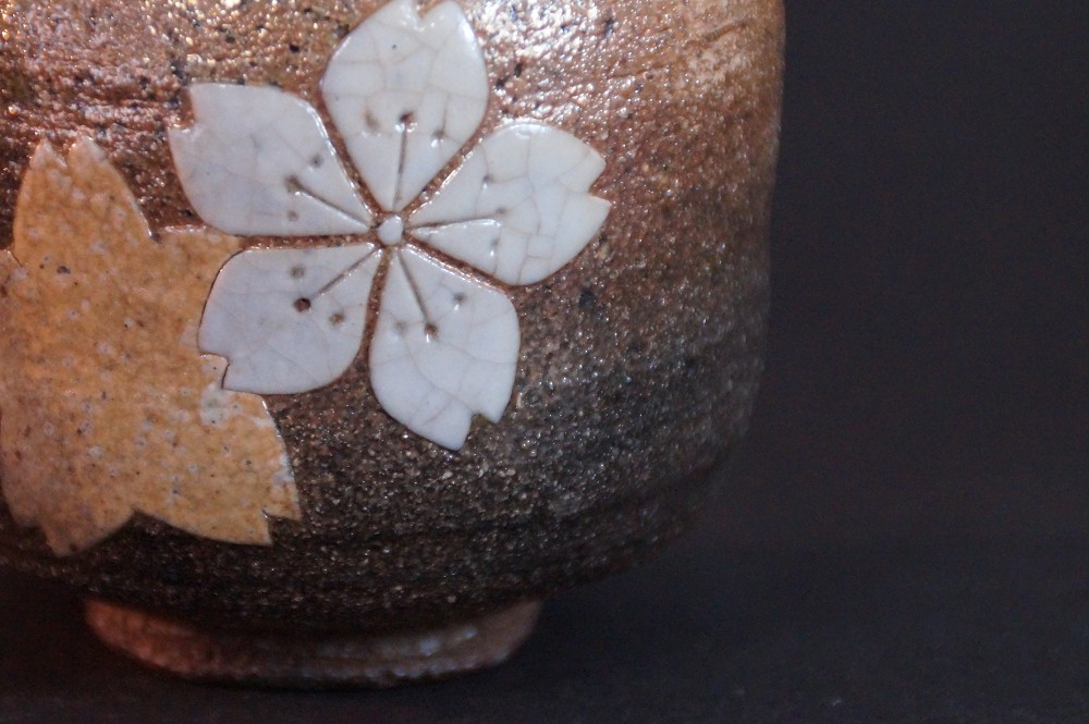 Extreme close-up of the inlaid cherry blossom in white and ocher