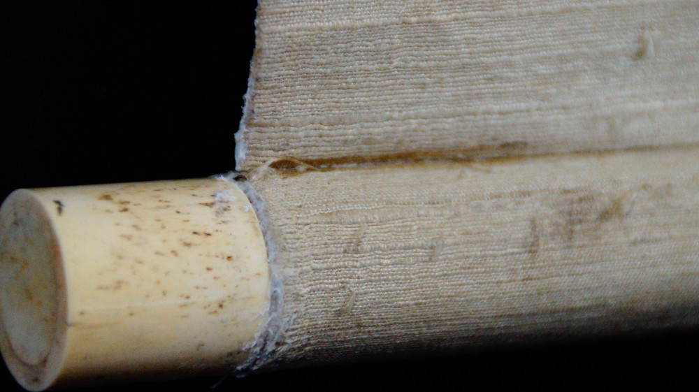 Close-up of the ivory-colored roller end of the hanging scroll