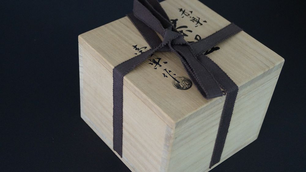 Closed storage box with cotton band and artist's seal of the chawan tea bowl made of Raku ware