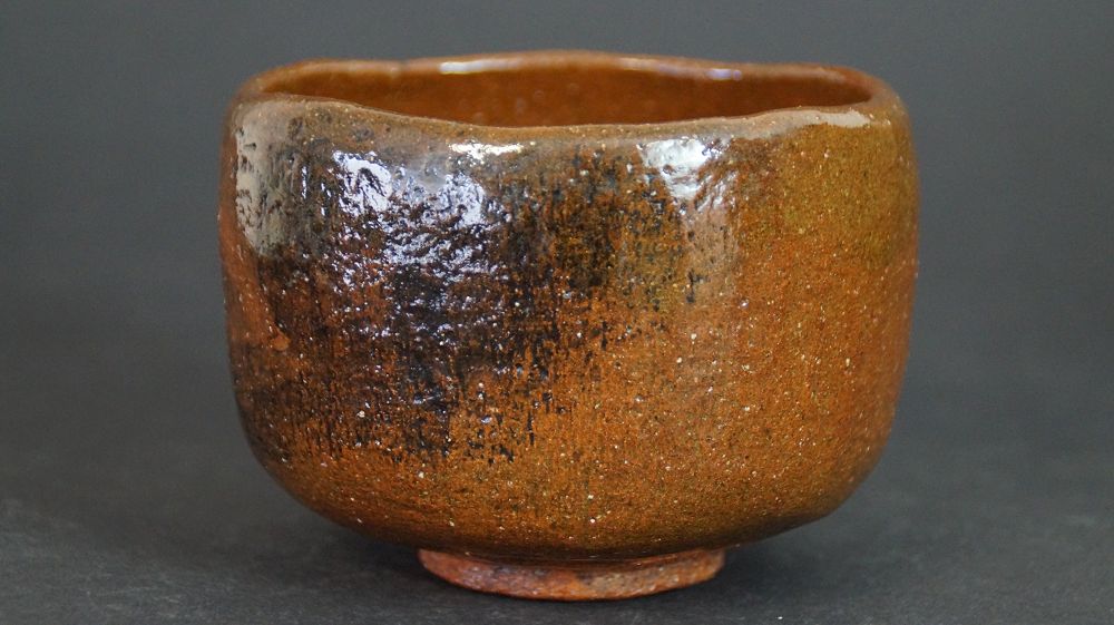 Further view of the chawan made of Ohi ware from the side with honey-brown glaze