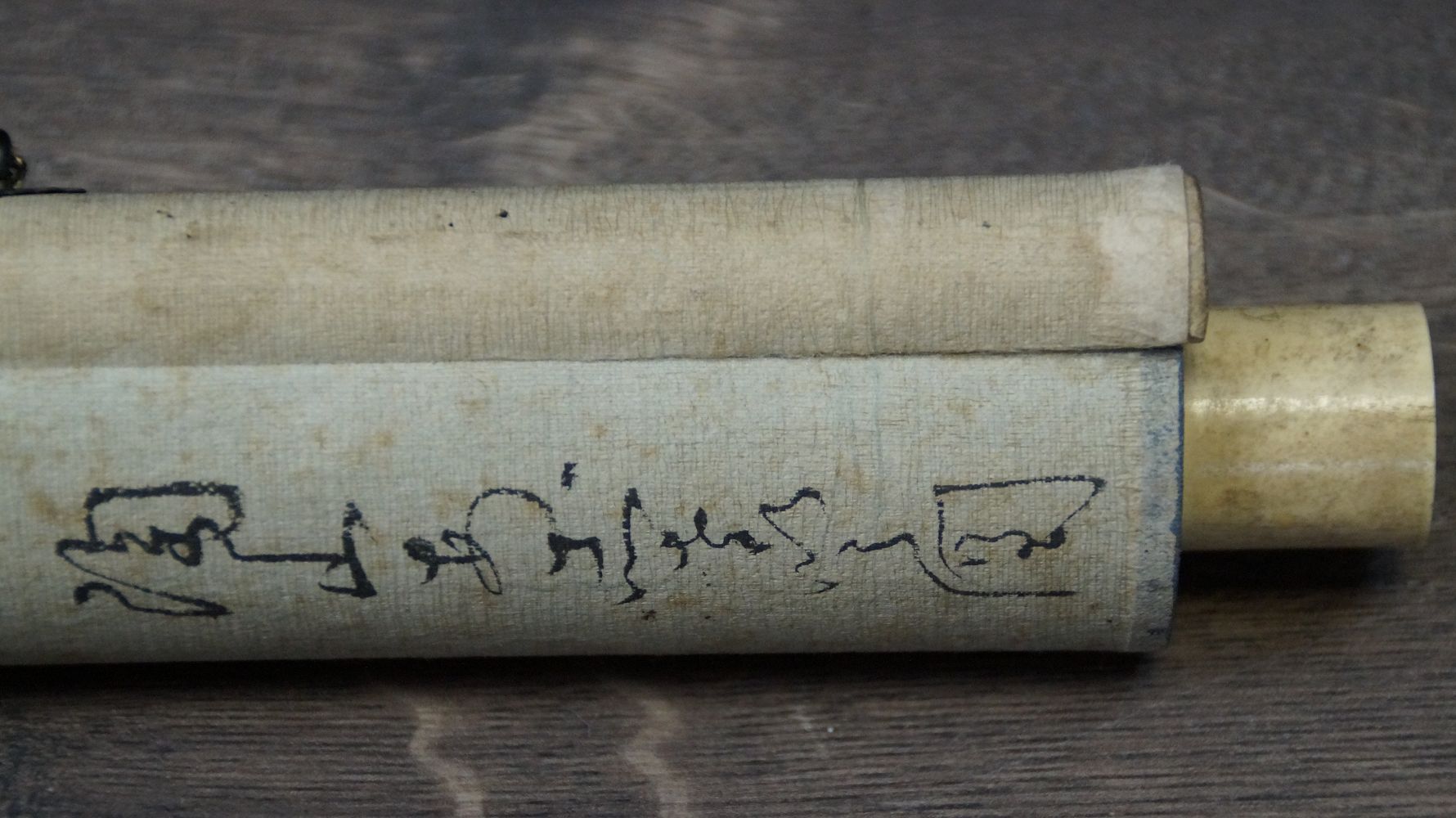 Detail view of the ivory-colored scroll end with handwritten inscription on the storage cover of the hanging scroll Hydrangeas in Early Summer Light