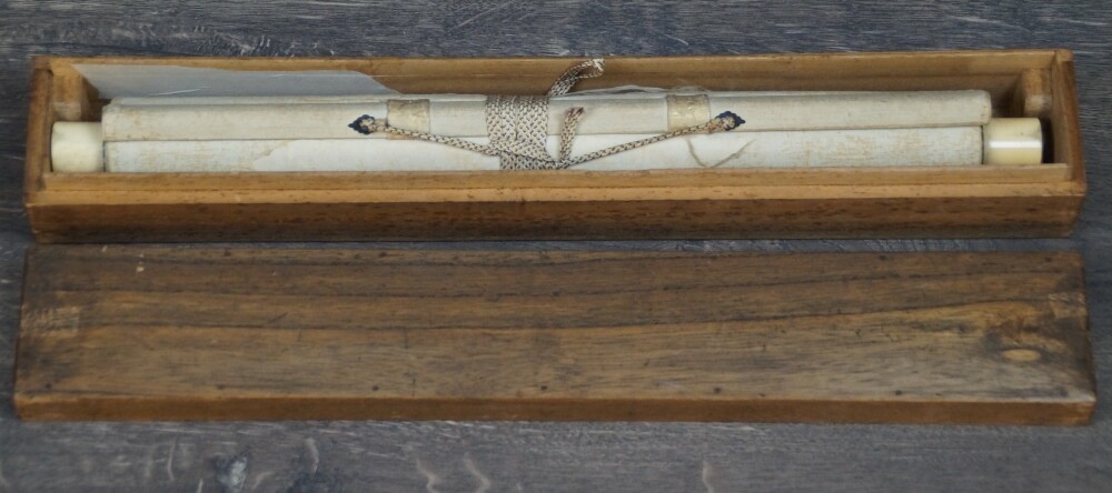 Rolled-up kakemono House in the Mist on a Mountain Slope with ivory-colored scroll ends in the opened storage box