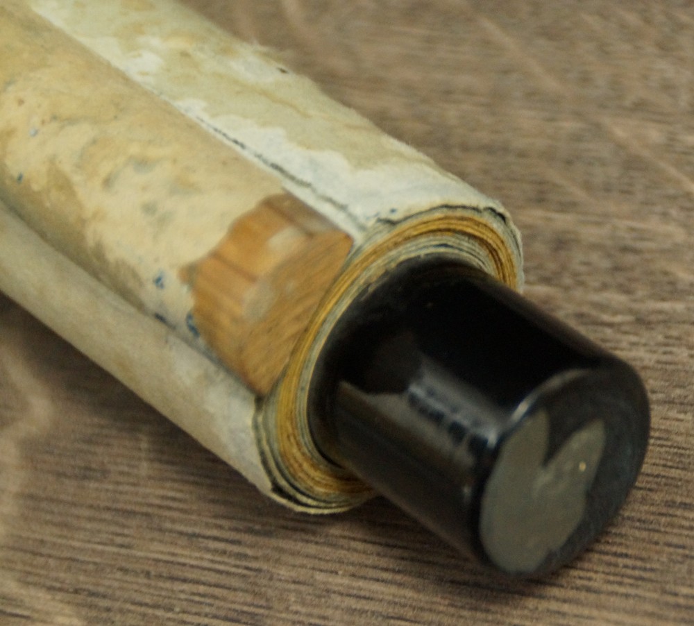 Close-up of the partially unrolled end with visible wooden dowel