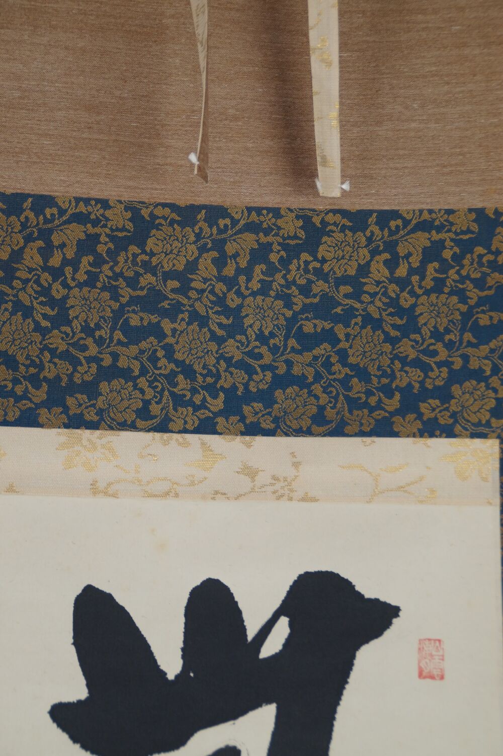 Detail view of the blue brocade silk mounting with hanging cords in the kakemono Calligraphy No Matters