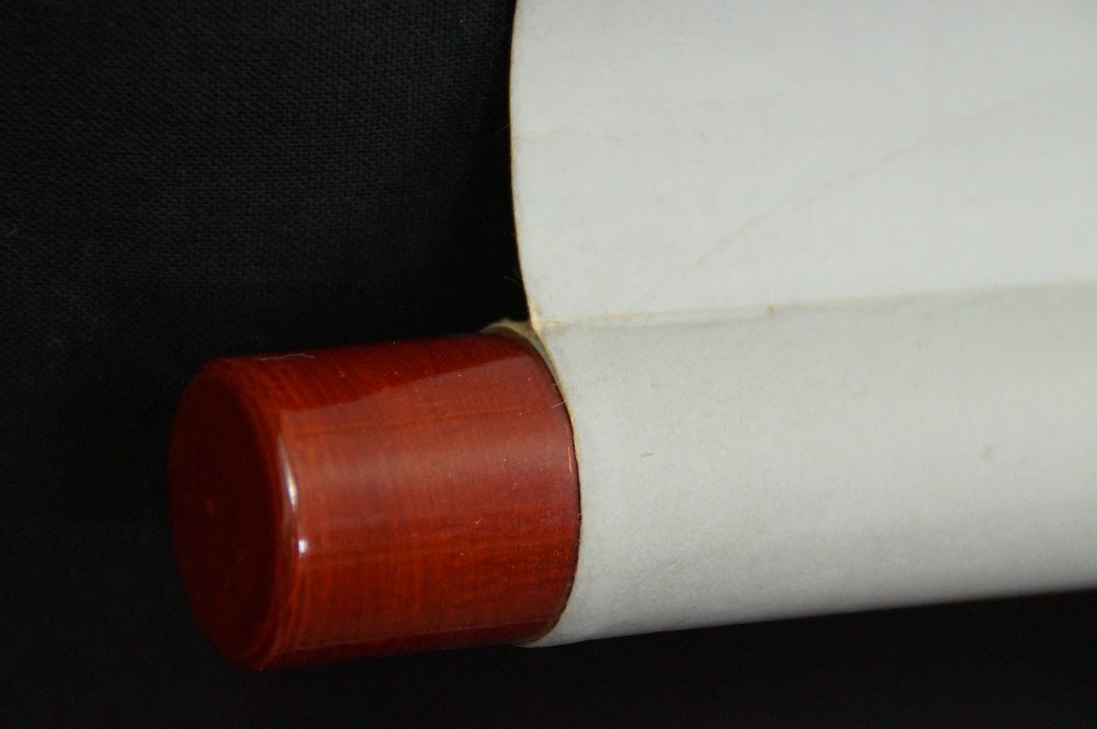 Close-up of the reddish-brown lacquered jikusaki at the end of the scroll
