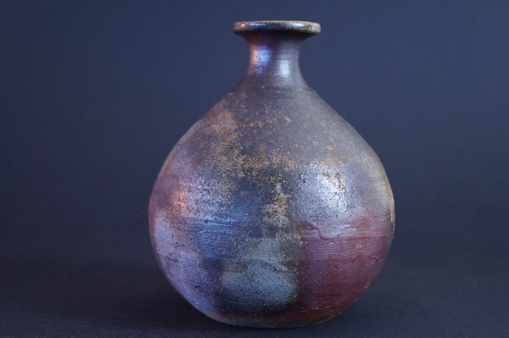 Additional side view of the tokkuri with reddish firing marks on the foot