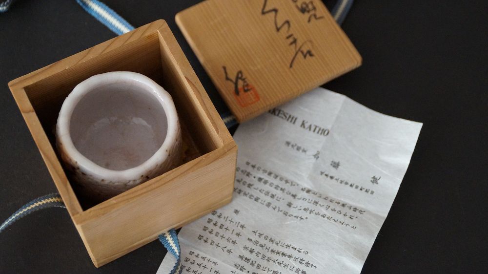 Guinomi made of Shino ware by Takeshi Kato next to the opened storage box with certificate of authenticity