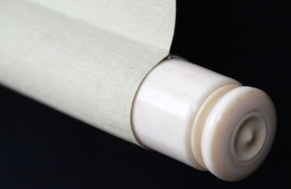 Detail view of the roller end with ivory knob and cream-colored silk of the hanging scroll Pomegranate Branch and Starling