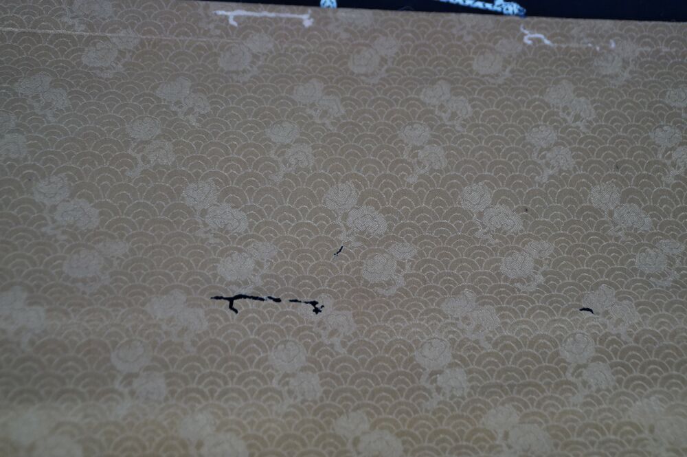 Further detail view of the gold-colored brocade silk mounting of the kakemono Heron in Quiet Peony Splendor