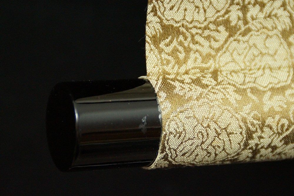 Close-up of the black lacquered jikusaki at the end of the scroll