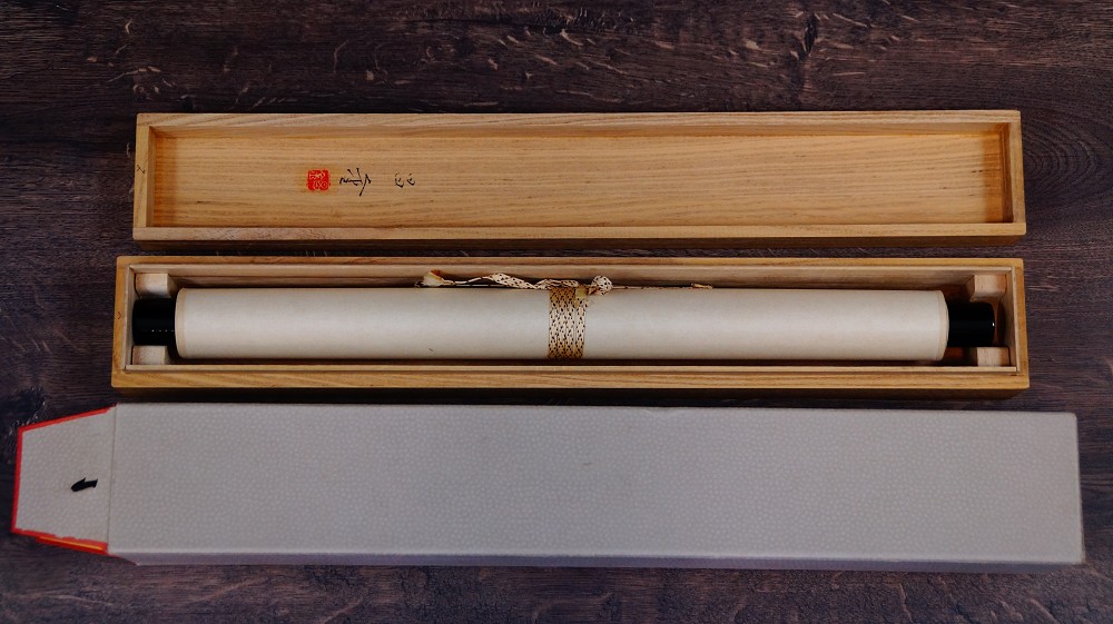 Rolled-up hanging scroll by Satomi Shokin in the opened storage box made of kiri wood
