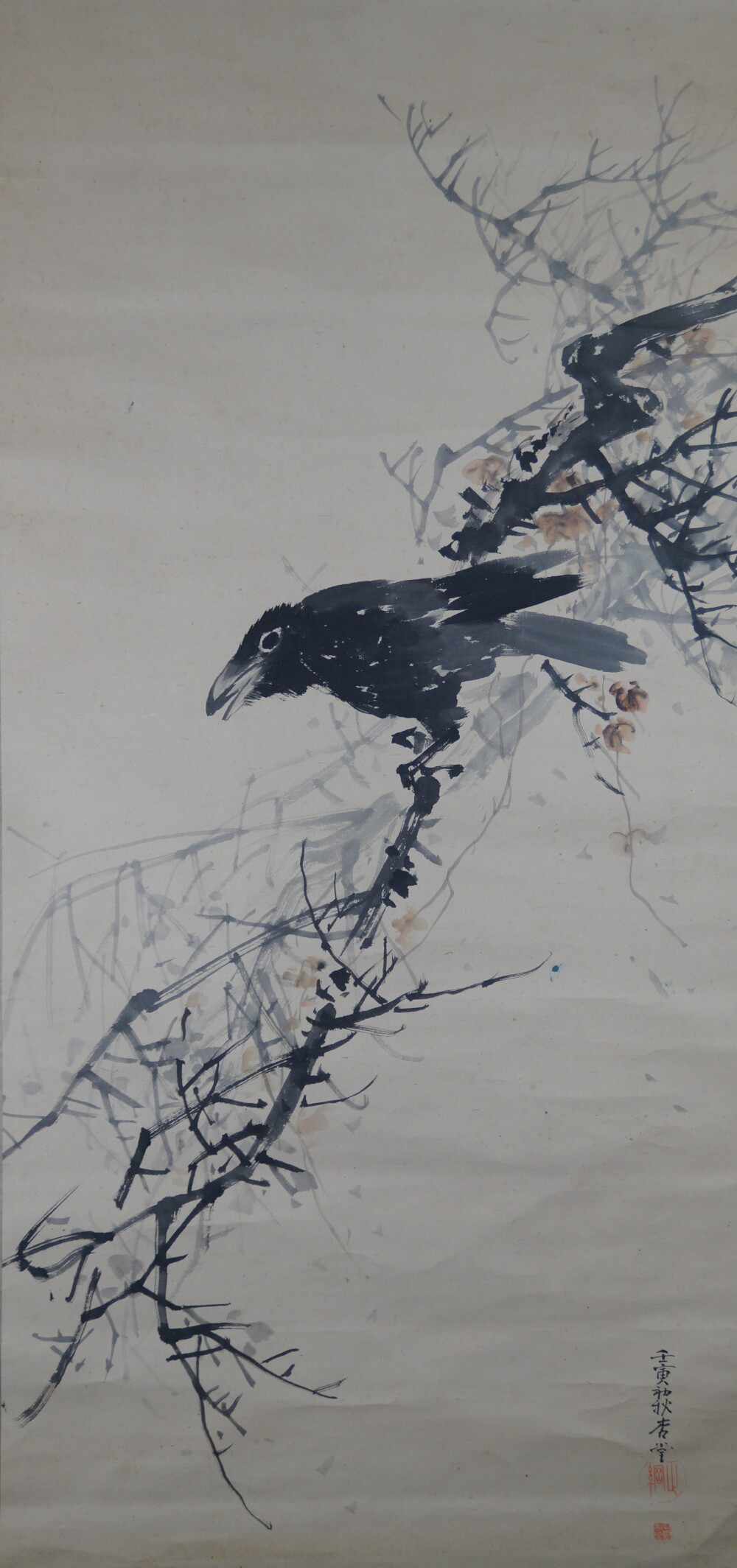 Raven on gnarled bare branch with scattered autumn leaves in the hanging scroll Raven on Bare Branch by Watanabe Ando with artist's signature and red seal