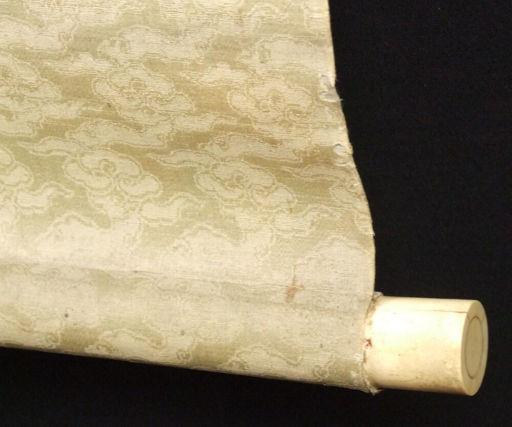 Detail view of the scroll end with ivory knob and cloud-pattern silk of the hanging scroll set
