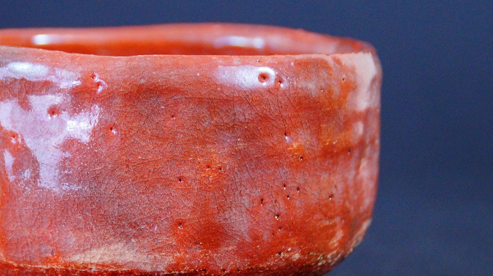 Close-up of the crackled red glaze of the chawan made of Raku ware by Sairi Hotoku