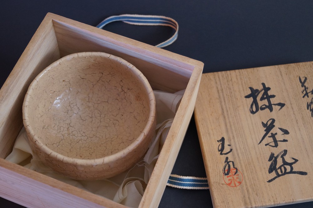 The tea bowl lying in the open storage box with signature