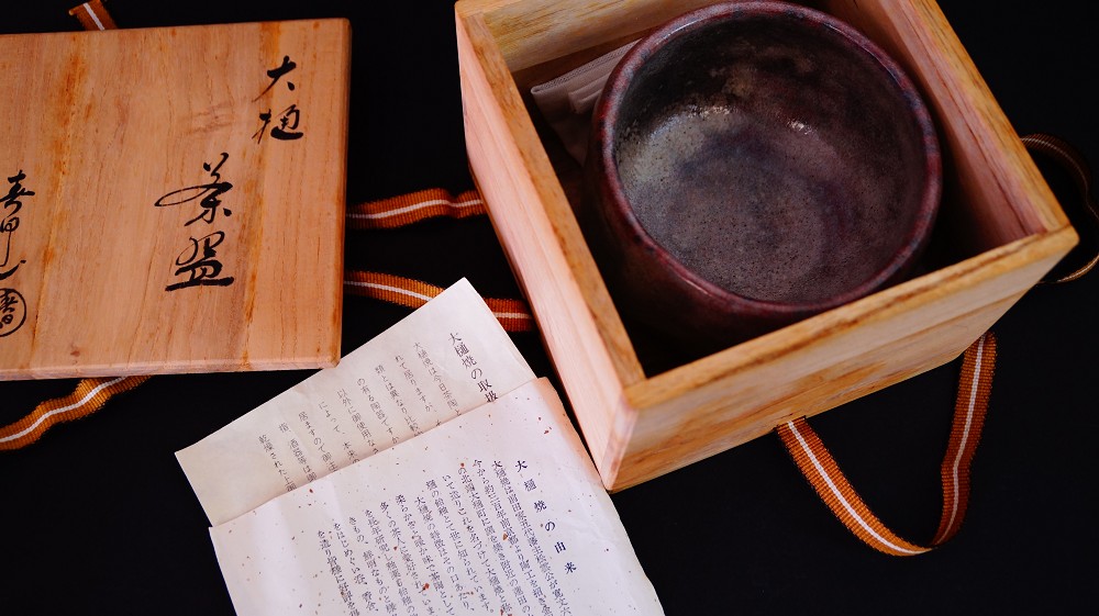 Chawan made of Ohi ware in the opened storage box next to the certificate of authenticity
